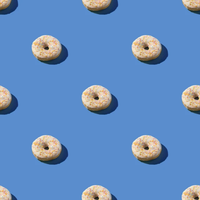 a bunch of donuts sitting on top of a blue surface, repeating pattern, cereal, sunlight, photoshop