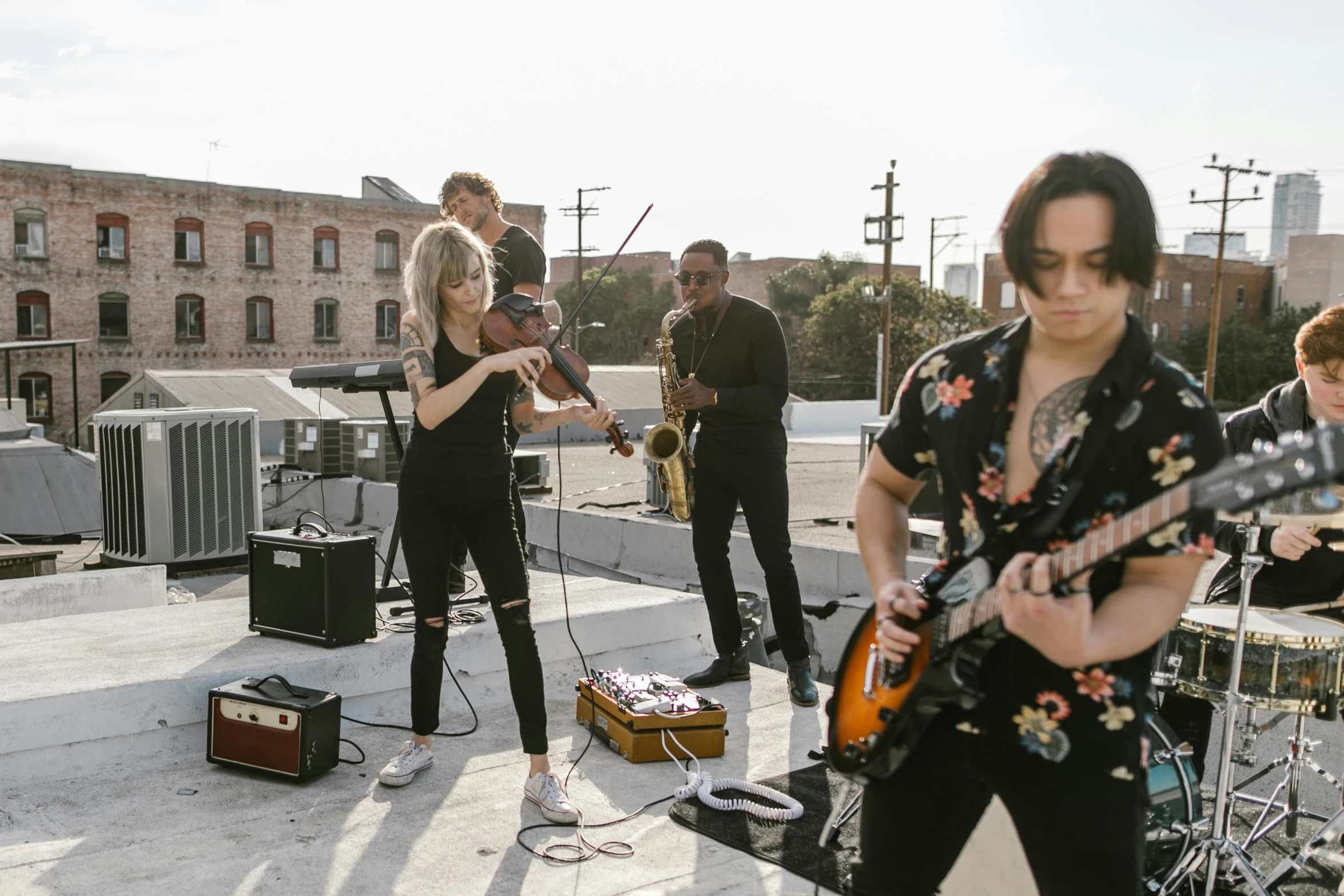 a group of people standing on top of a roof, an album cover, by Carey Morris, pexels contest winner, antipodeans, holding electric guitars, blond, live performance, los angelos