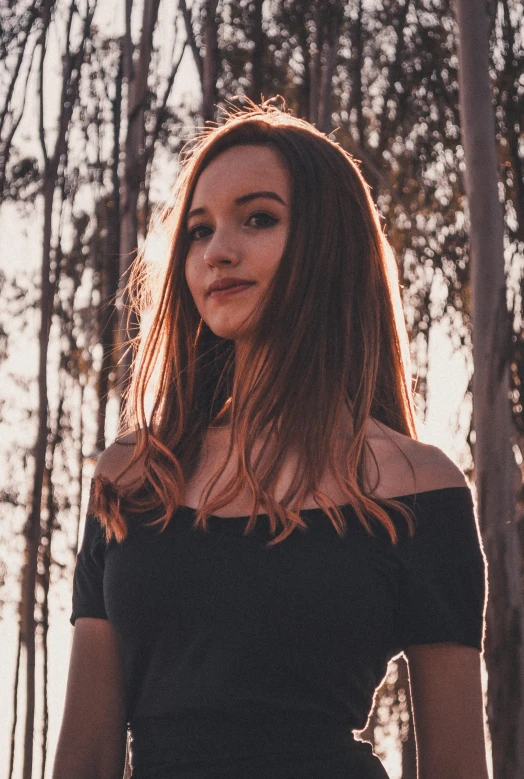 a woman standing in the middle of a forest, an album cover, unsplash, with brown hair, ((sunset)), 1 8 yo, with a black background