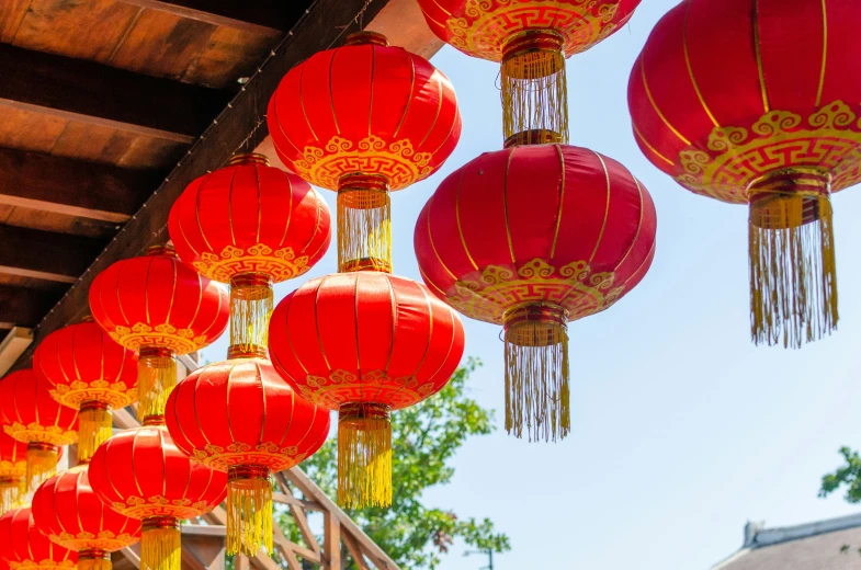 a bunch of red lanterns hanging from the side of a building, inspired by Li Di, trending on unsplash, sunny sky, 🦩🪐🐞👩🏻🦳, oriental scene, red and yellow light