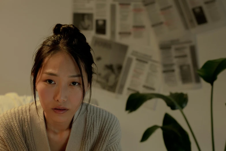 a woman sitting on top of a bed next to a plant, inspired by Kim Tschang Yeul, trending on pexels, hyperrealism, film still from the movie, young adorable korean face, looking from shoulder, lights on