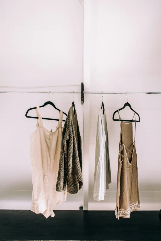 clothes hanging on a clothes rack in a room, by Nina Hamnett, unsplash, minimalism, wearing a camisole, white and gold robes, milk and mocha style, 15081959 21121991 01012000 4k