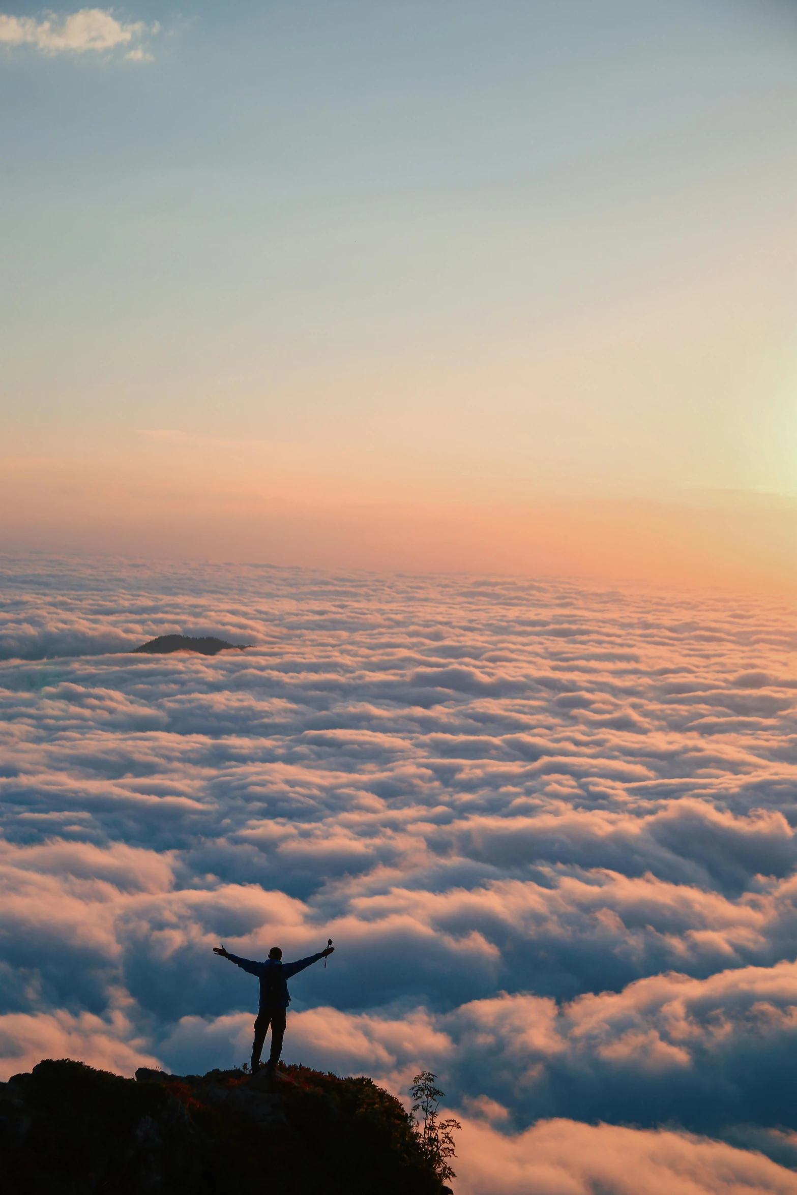 a person standing on top of a mountain above the clouds, sunset kanagawa prefecture, smiling down from above, 2019 trending photo, arms spread wide