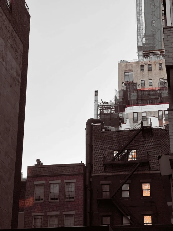 a couple of tall buildings sitting next to each other, a photo, unsplash, harlem renaissance, low quality photo, hiding in the rooftops, ignant, spooky photo