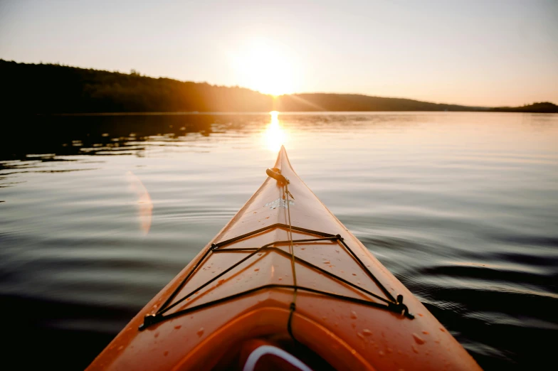 a kayak sitting on top of a body of water, pexels contest winner, warm light, fan favorite, opening shot, on the bow