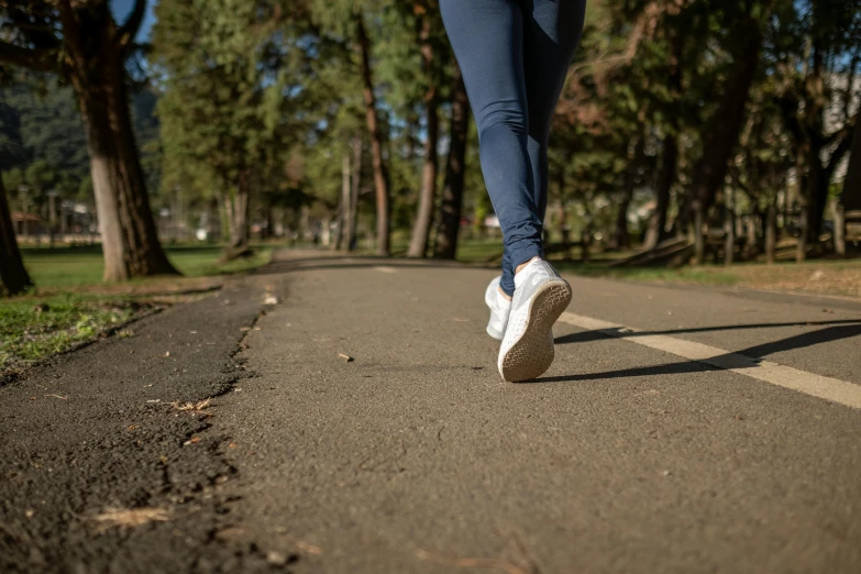 a person walking on a road with trees in the background, wearing white sneakers, working out, 15081959 21121991 01012000 4k, background image