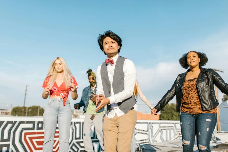 a group of people standing next to each other on a pier, an album cover, trending on pexels, renaissance, diverse outfits, on rooftop, riverdale, performing a music video