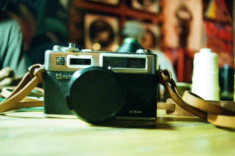 a camera sitting on top of a wooden table, a picture, for 1 9 7 0 s'sci - fi, lo fi, icon, fujifilm x100v