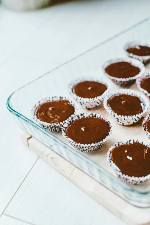 a glass baking dish filled with chocolate cupcakes, by Nicolette Macnamara, unsplash, chocolate candy bar packaging, deckle edge, thumbnail, assembled