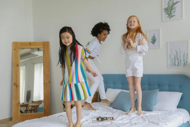 a group of young girls standing on top of a bed, pexels, happening, running freely, cool white, 3 colours, sleepwear