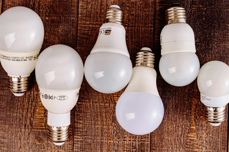 a group of light bulbs sitting on top of a wooden table, various sizes, cool white color temperature, fan favorite, test