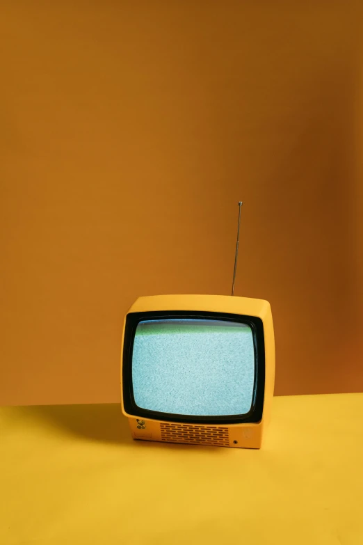a small television sitting on top of a yellow surface, tv show, crt tubes, instagram picture, midcentury modern