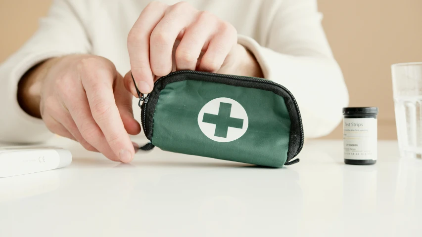 a person holding a green first aid bag, a picture, by Emma Andijewska, trending on pexels, rectangle, pharmacy, pair of keycards on table, viewed from the side