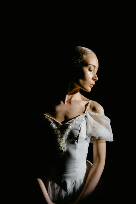 a woman in a white dress posing for a picture, a portrait, by Winona Nelson, arabesque, dark ballerina, looking off to the side, getty images proshot, detailed light