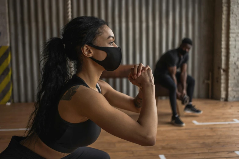 a woman squatting while wearing a face mask, male and female, dim dingy gym, profile image, essence