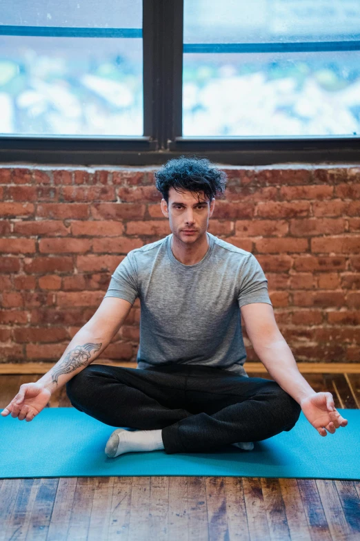 a man sitting on a yoga mat in front of a window, a portrait, inspired by John Luke, trending on pexels, eng kilian, square, confident stance, 8k octan photo