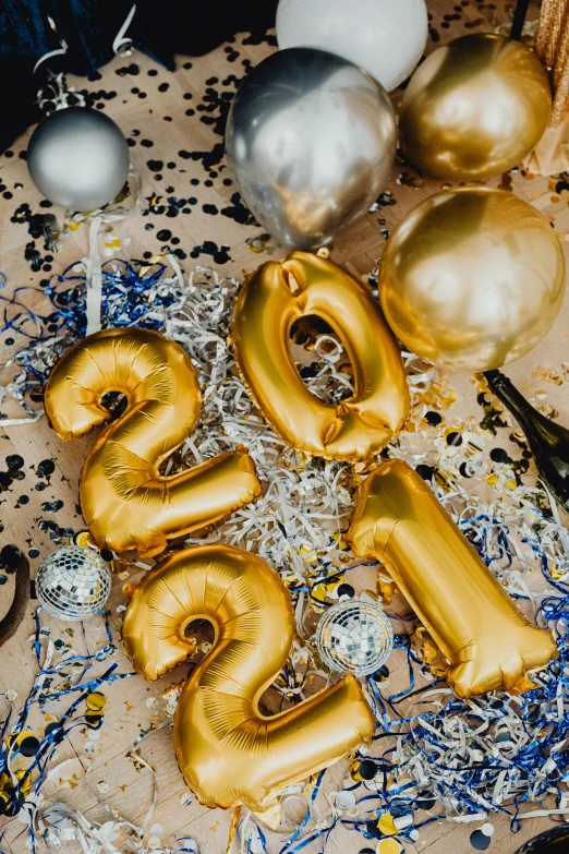 a table topped with gold balloons and confetti, 2019 trending photo, 21 years old, various items, high angle close up shot