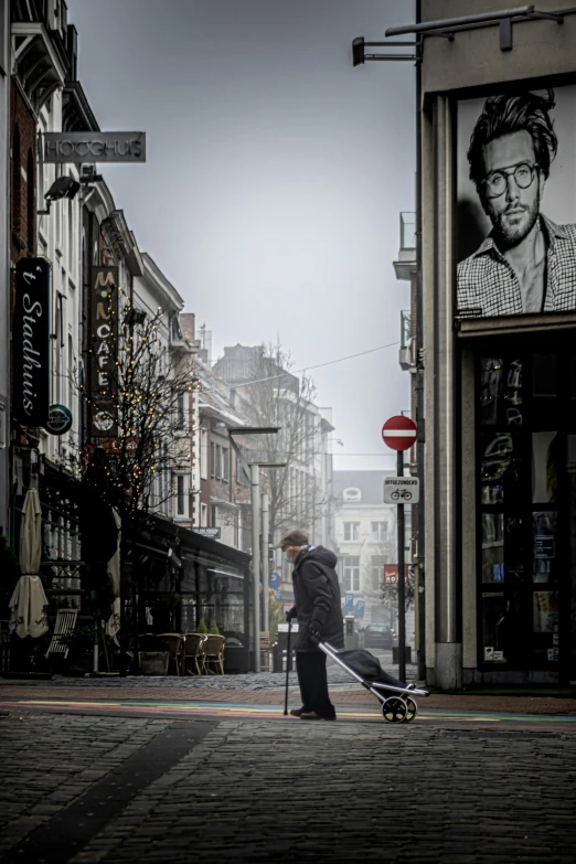 a man riding a skateboard down a street next to tall buildings, inspired by Peter Lindbergh, pexels contest winner, street art, brussels, foggy rainy day, an old lady, lots of shops