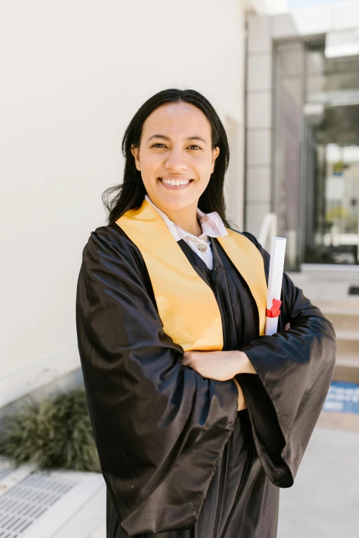 a woman in a graduation gown standing in front of a building, ana de la reguera portrait, portrait image