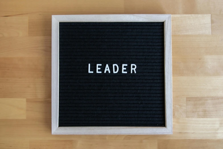 a letter board with the word leader written on it, an album cover, trending on unsplash, letterism, square, black, teacher, leathery