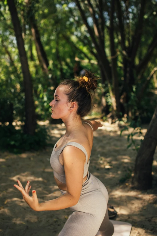 a woman throwing a frisbee in a wooded area, unsplash, renaissance, hair styled in a bun, padmasana, profile image, full frame image