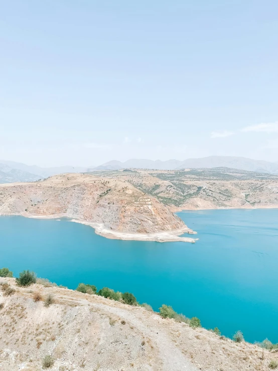 a large body of water sitting on top of a hill, by Muggur, light blue water, kurdistan, marbella landscape, high res 8k