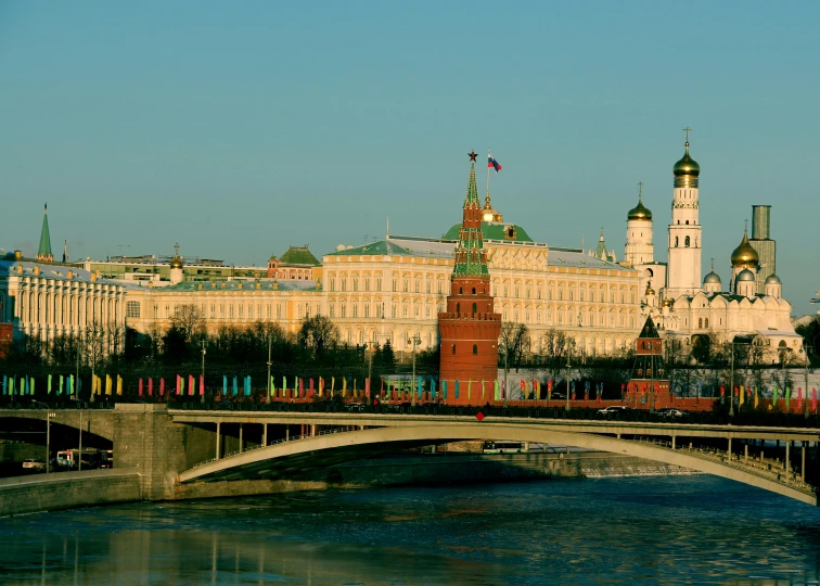 a bridge over a river with a building in the background, an album cover, inspired by Vasily Surikov, pexels contest winner, socialist realism, kremlin, square, skyline showing, promo image