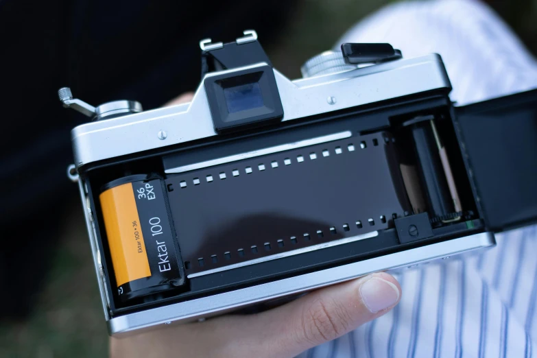 a close up of a person holding a camera, kodak ektochrome film, looking down on the camera, close up to the screen, epic scale ultrawide angle
