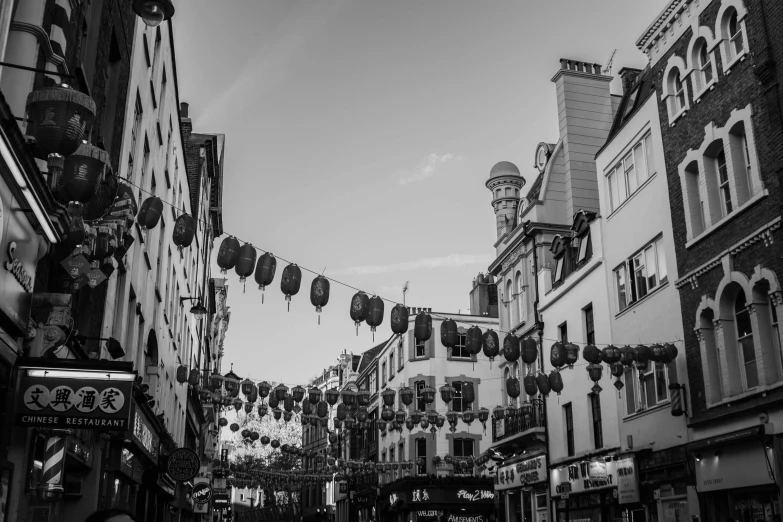 a black and white photo of a city street, a black and white photo, pexels, art nouveau, floating chinese lampoons, festive atmosphere, 2 4 mm iso 8 0 0 color, beautifully daylight