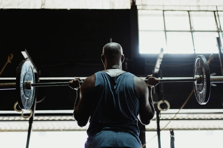 a man lifting a barbell in a gym, a portrait, by Carey Morris, pexels contest winner, hurufiyya, from back, rodney matthew, faded and dusty, thumbnail