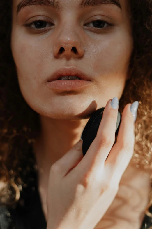 a close up of a person holding a cell phone, beautiful oval face, essence, vibrating, with black