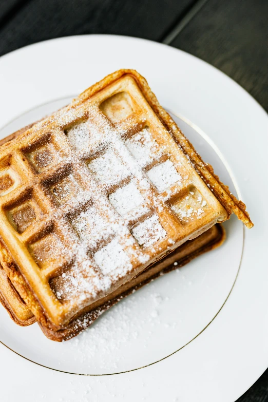 a white plate topped with waffles covered in powdered sugar, 🚿🗝📝, epicurious, 2 5 6 x 2 5 6 pixels, grey