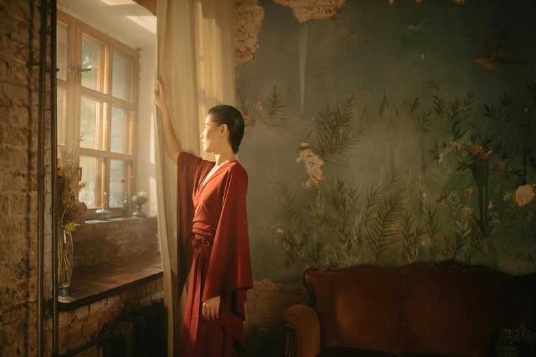 a woman in a red robe looking out a window, inspired by Anka Zhuravleva, pexels contest winner, magical realism, wearing ancient chinese clothes, standing in corner of room, still from film, still image from tv series