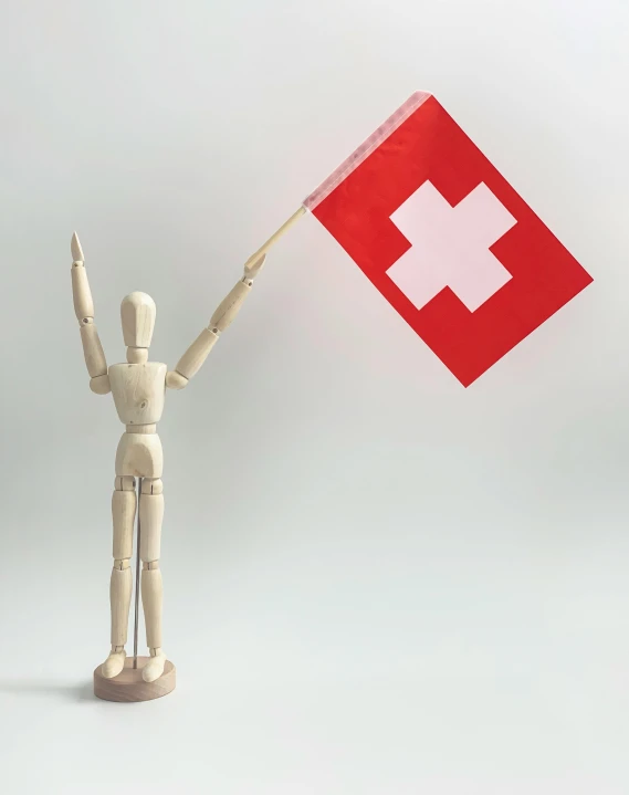 a wooden mannequin holding a swiss flag, inspired by Karl Stauffer-Bern, pexels contest winner, medical supplies, raised hand, 1 figure only, pvc posable figure