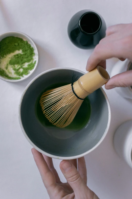 a person holding a whisk in a bowl of green tea, inspired by Kanō Shōsenin, brushed, bio-inspired, multi-part, uk