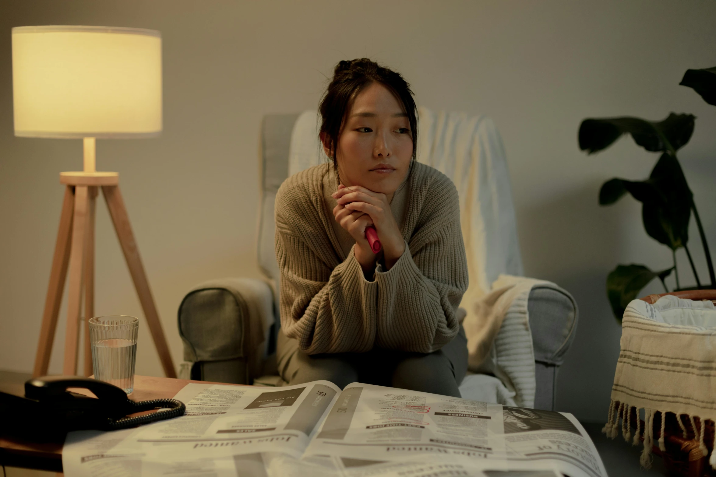 a woman sitting on a couch in a living room, by Jang Seung-eop, pexels contest winner, hyperrealism, still from a live action movie, emerging from her lamp, concerned expression, akiko takase