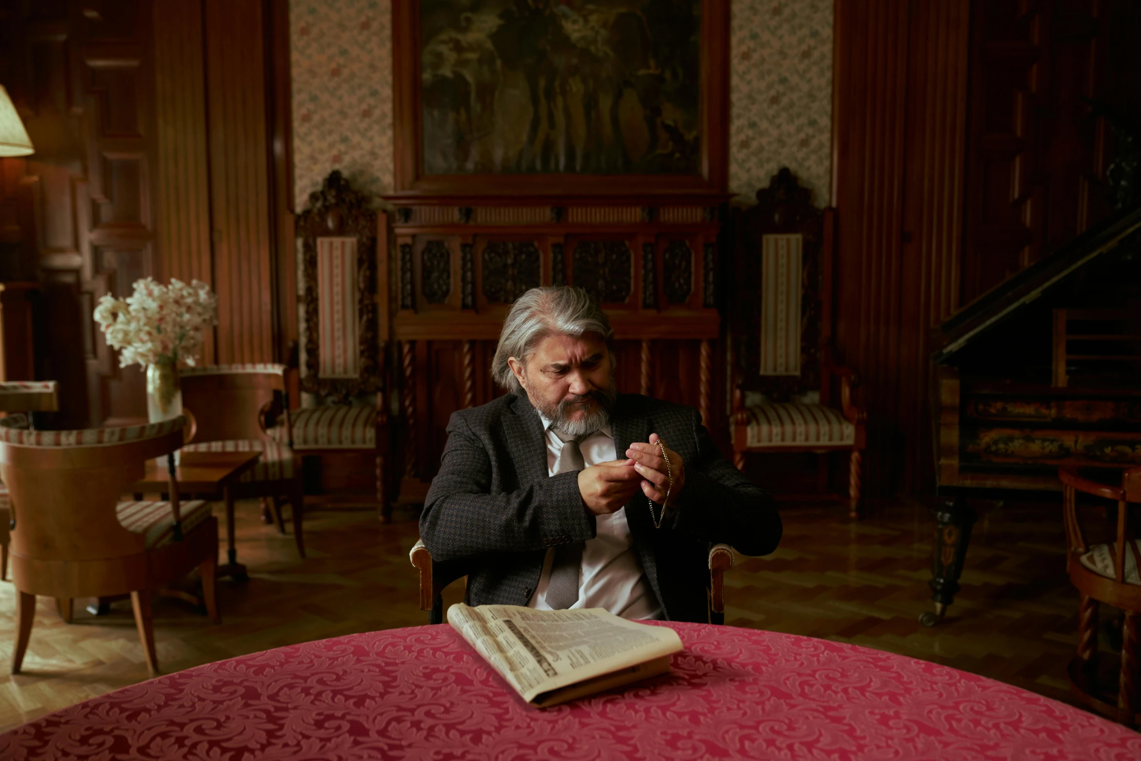 a man sitting at a table reading a book, a portrait, by Kazimierz Wojniakowski, pexels contest winner, baroque, still from a terence malik film, slavoj zizek, in their noble mansion, mat collishaw