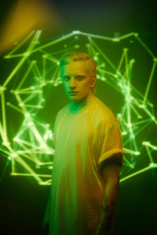 a man standing in front of a green light, inspired by Mike Winkelmann, holography, blonde boy with yellow eyes, promo shot, cosmic, draco