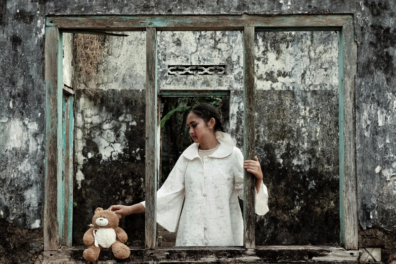 a woman holding a teddy bear in front of a window, by Lucia Peka, indonesia, white clothes, ruin, portrait image