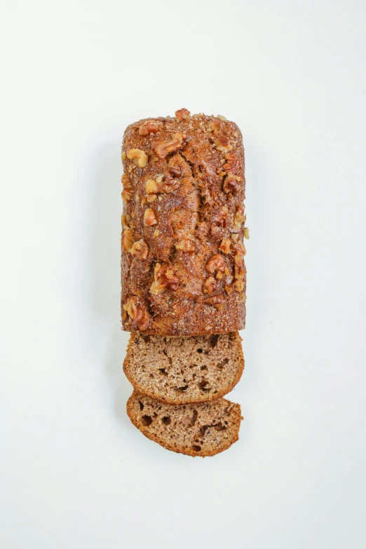 a loaf of bread sitting on top of a white surface, walnuts, detailed product image, banana, top down shot