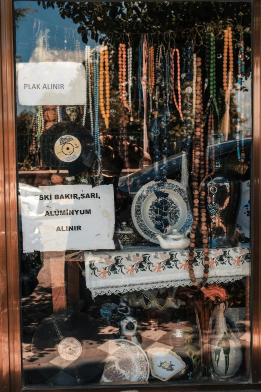 a store window filled with lots of different items, a poster, unsplash, assemblage, turkish and russian, beads, etched inscriptions, 2. sigara aşırmak