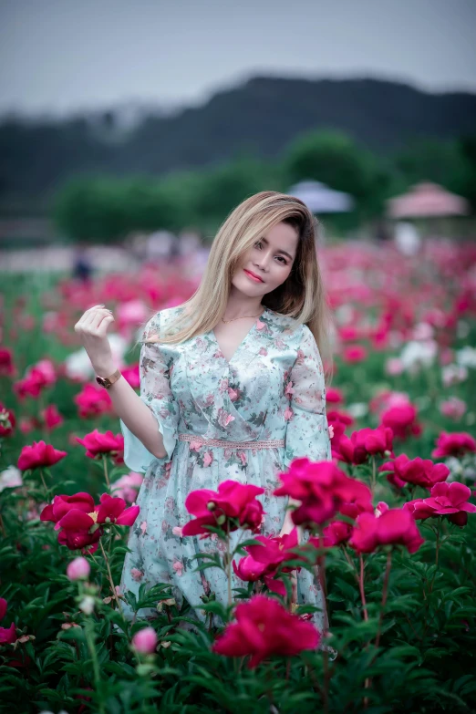 a woman standing in a field of flowers, a picture, by Reuben Tam, pexels contest winner, roses, square, casual pose, malaysian