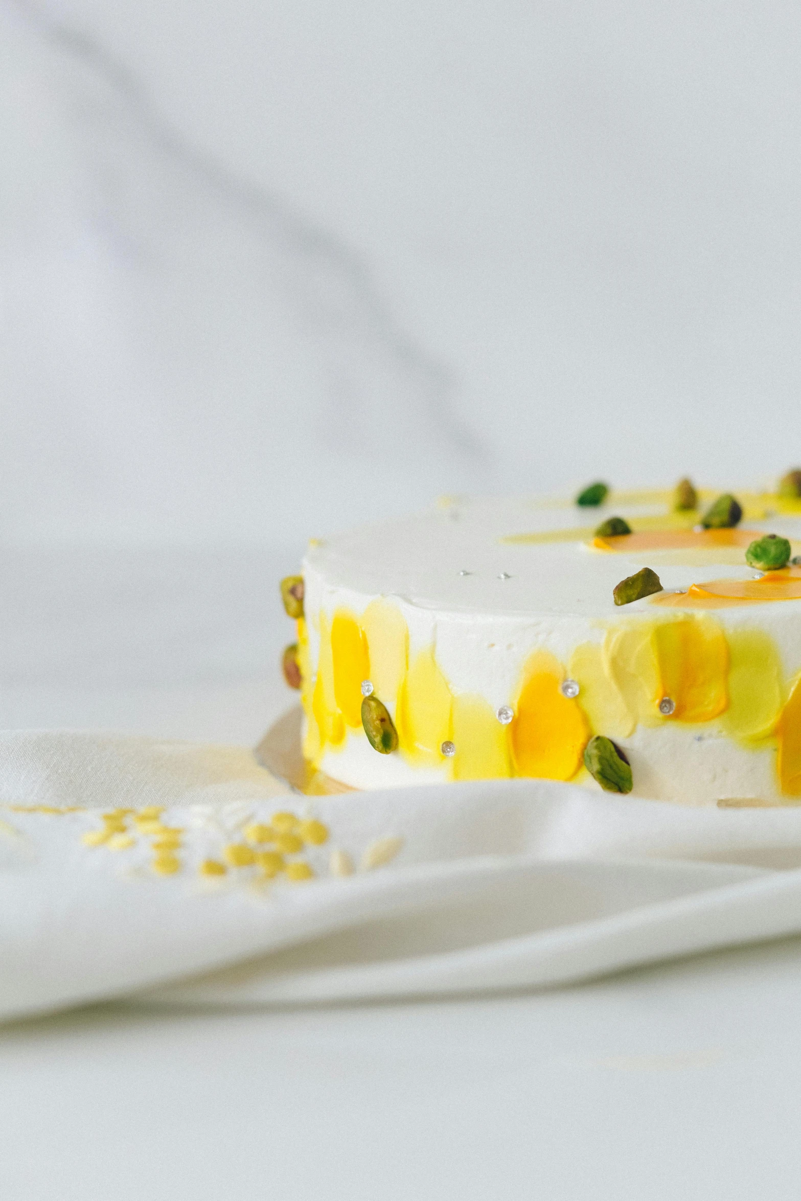 a piece of cake sitting on top of a white cloth, by Jessie Algie, trending on unsplash, arabesque, yellow and greens, cheeses, resin, detailed product image