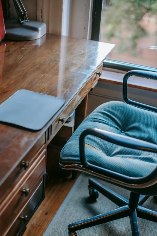 a laptop computer sitting on top of a wooden desk, old chairs, plush leather pads, sydney hanson, full width