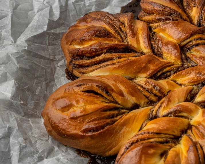 a bunch of braided bread sitting on top of a piece of tin foil, by Adam Marczyński, trending on pexels, baroque, chocolate, vine twist, high resolution photo, rosette