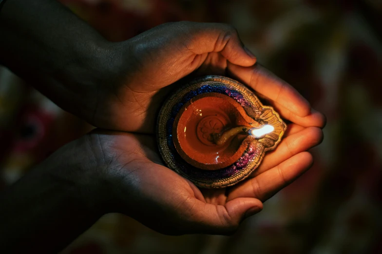 a person holding a lit candle in their hands, pexels contest winner, hindu ornaments, avatar image, print ready, instagram post