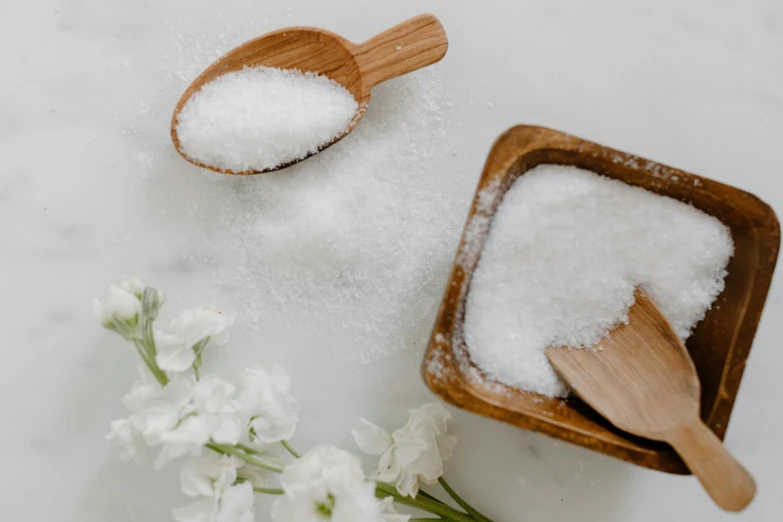 a wooden bowl filled with white sugar next to a wooden spoon, trending on pexels, flowers around, sparkling, background image, full-body