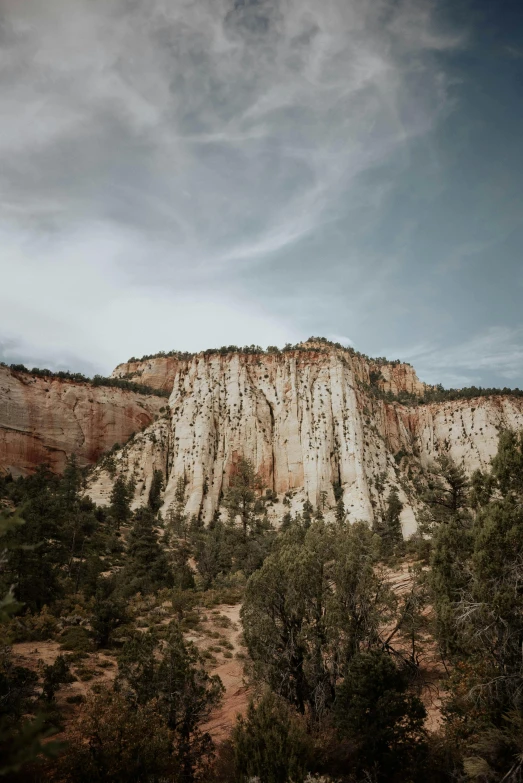 a man riding a snowboard on top of a snow covered slope, a picture, unsplash contest winner, les nabis, trees and cliffs, utah, slightly pixelated, tall stone spires