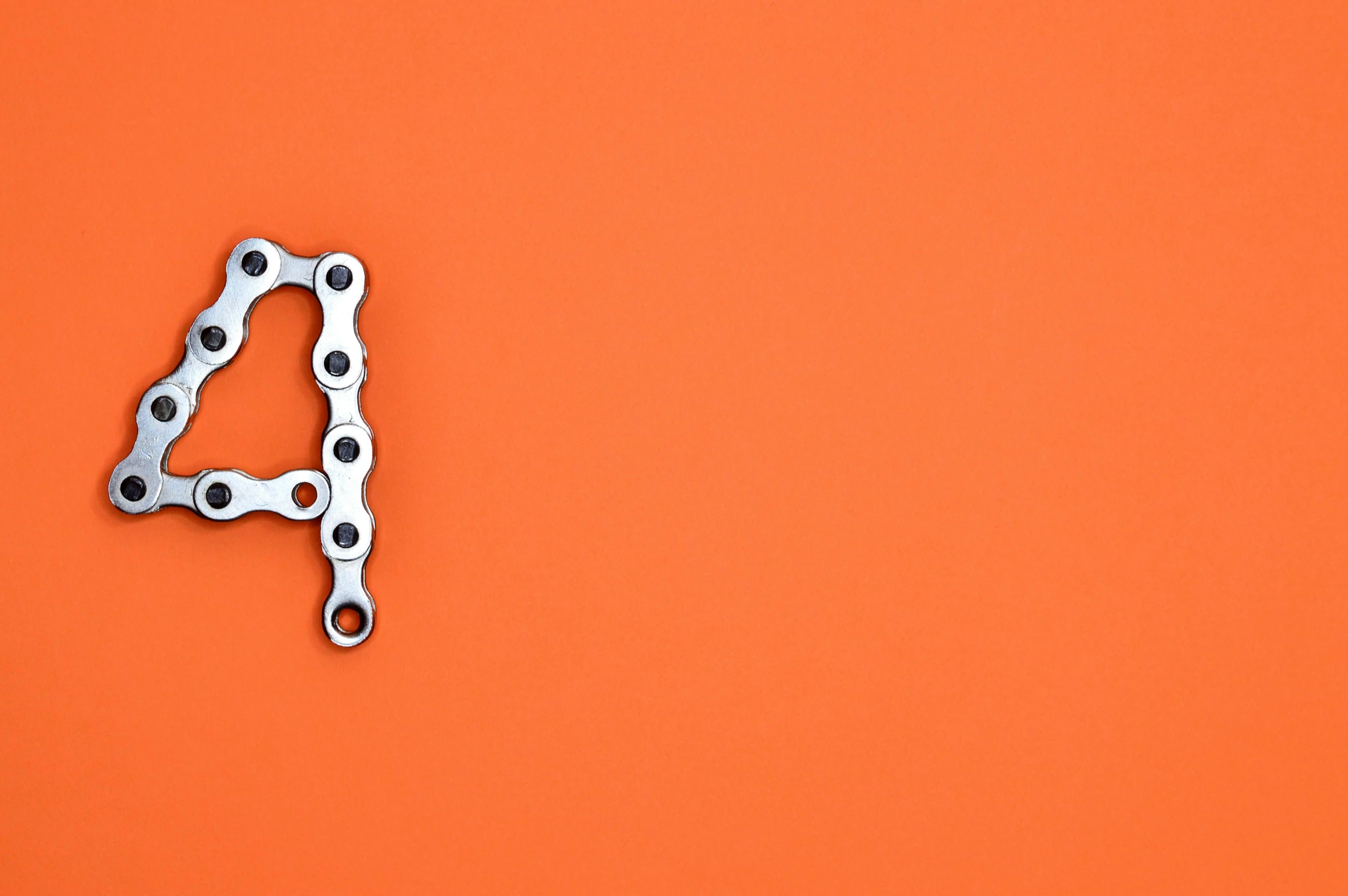 a bicycle chain number four on an orange background, unsplash, assemblage, adafruit, 🚿🗝📝