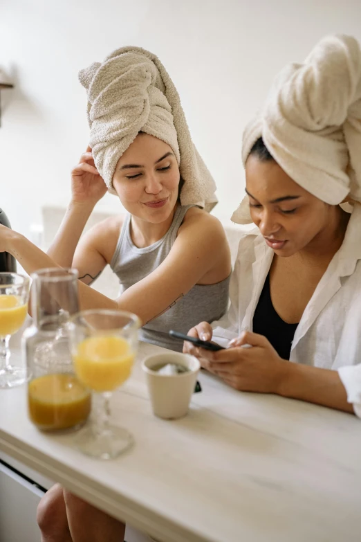 a couple of women that are sitting at a table, trending on pexels, wearing a towel, tech robes, essence, breakfast